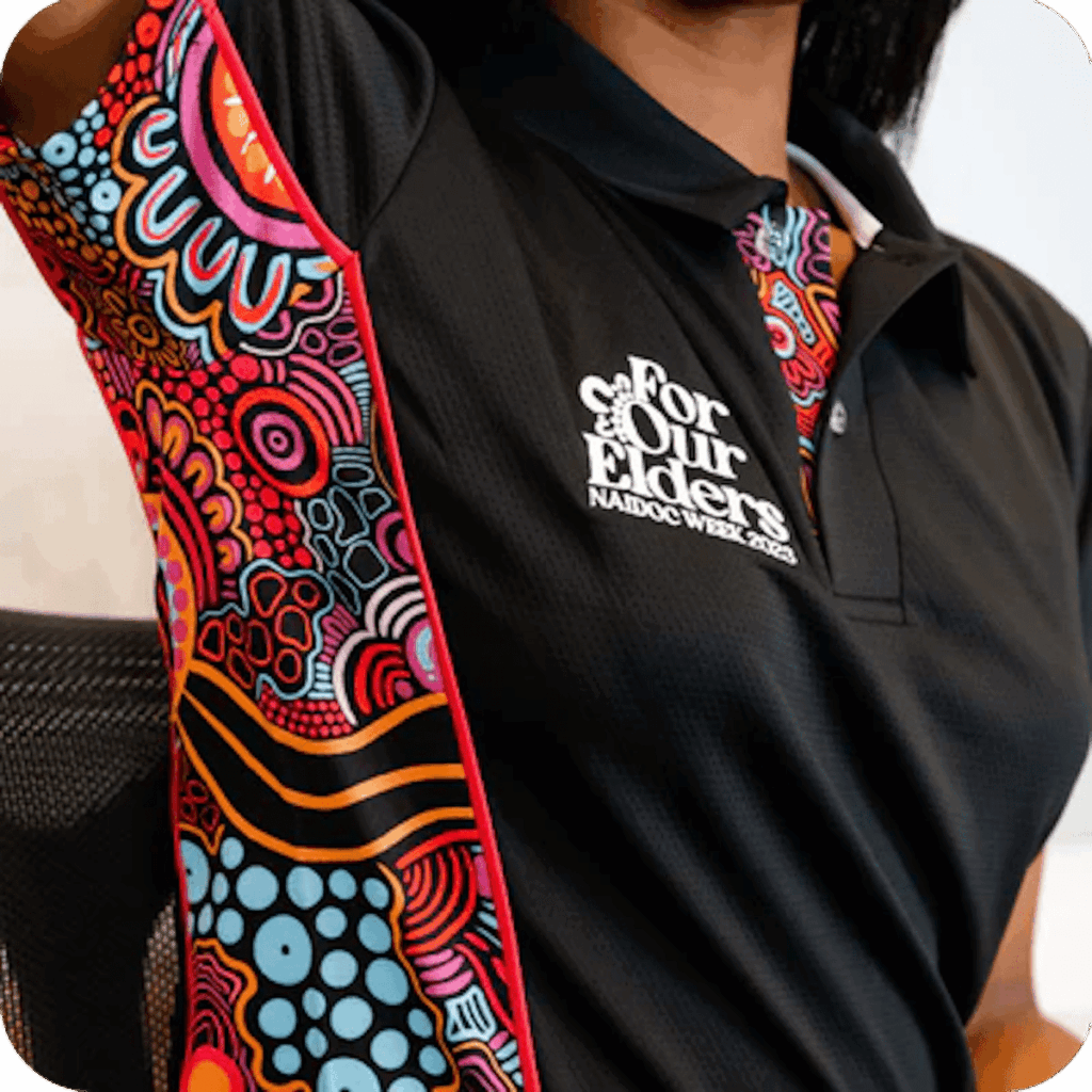 NAIDOC Week polo with Aboriginal artwork and For Our Elders message — custom branded options available.